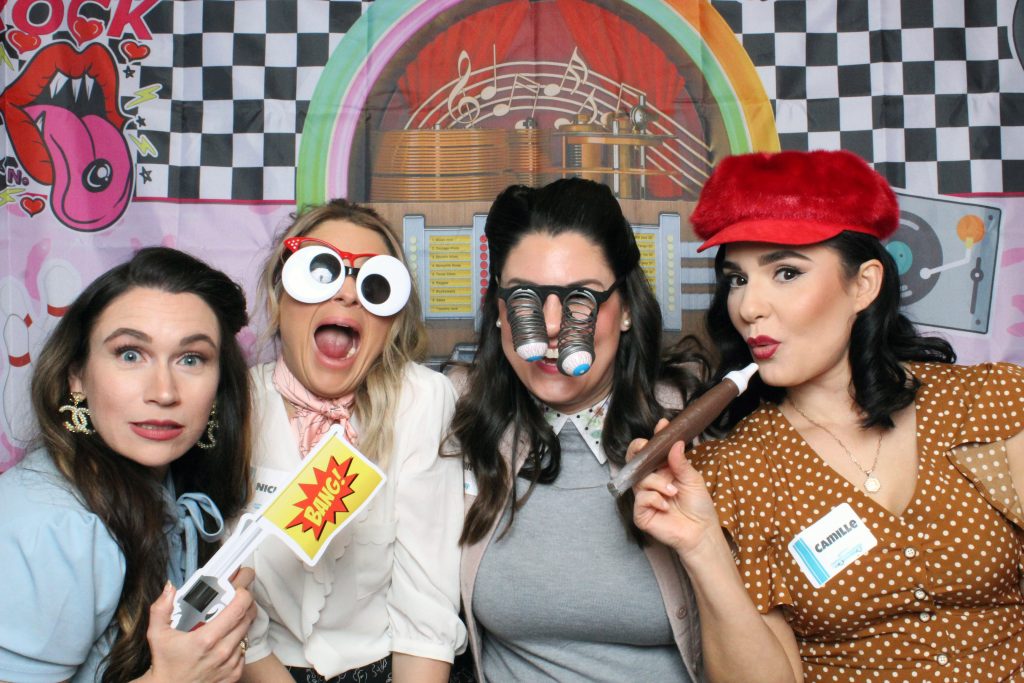 50's styled ladies taking a selfie with photo booth props at Ernie's Birthday