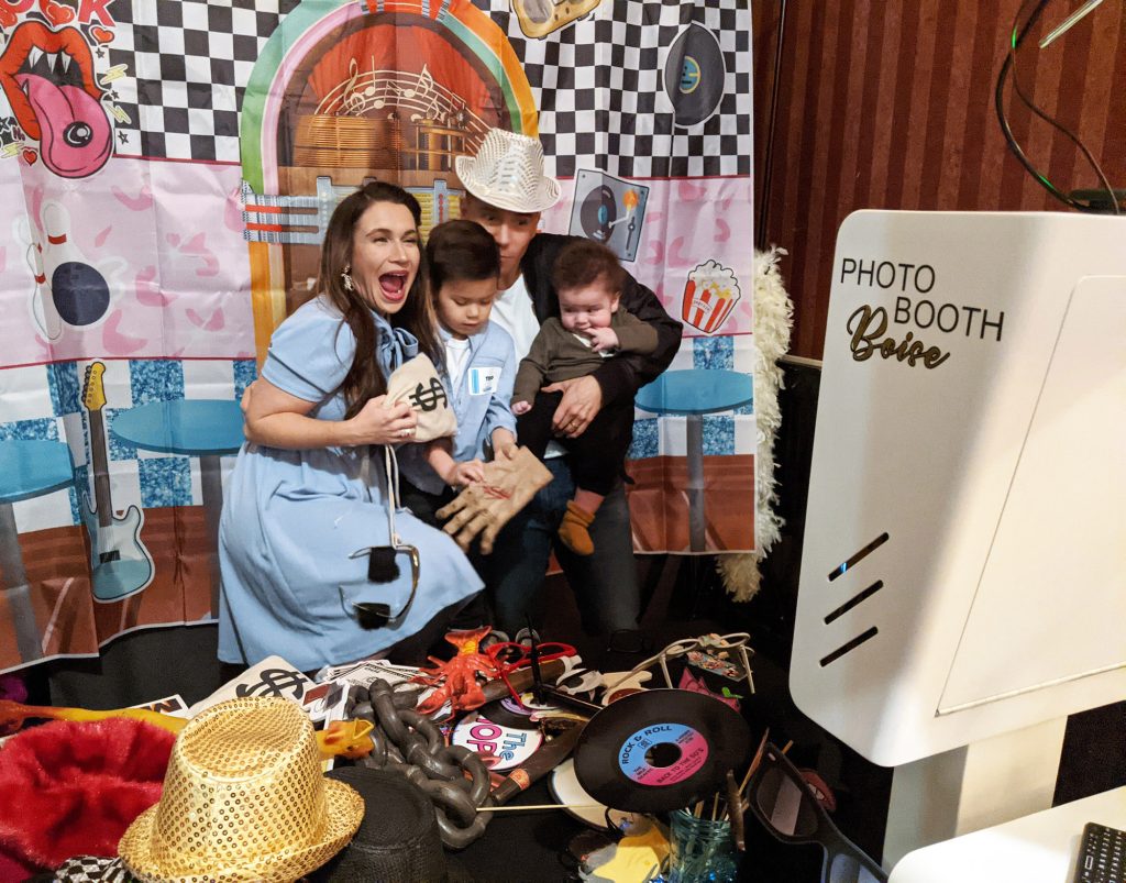 A family dressed up for the sock hop posing for the birthday photo booth