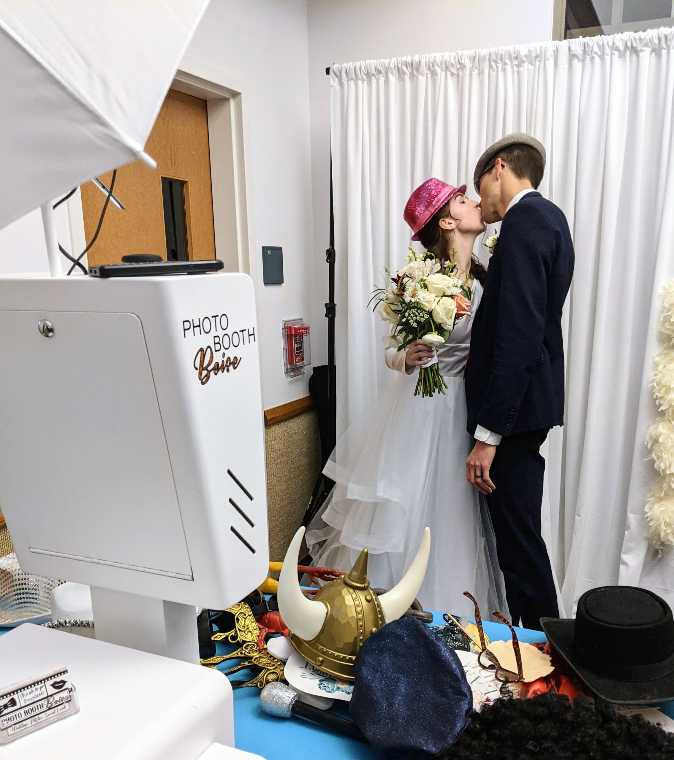 Bride and groom kissing for a photo at the open air photo booth