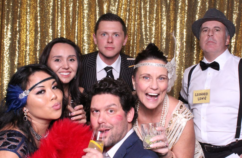 Guests posing in 20's attire for a photo booth picture