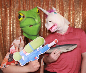 Using all the party photo booth props! Unicorn and frog masks for the win.