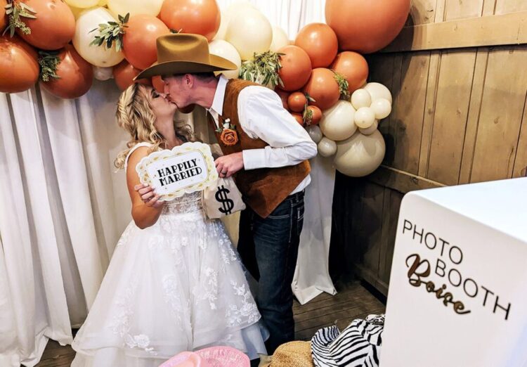 Newly married bride and groom kissing in Photo Booth Boise's DLSR Open-Air photo booth